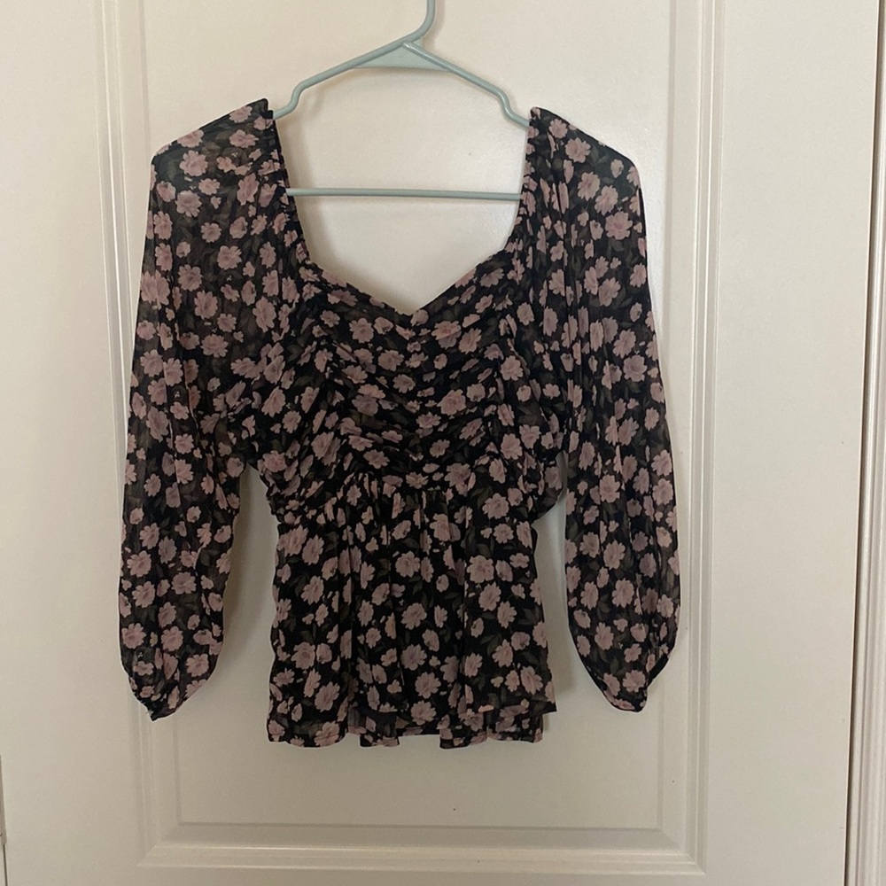 Floral top. Sleeves are mid length and the top has some peplum detail to it.